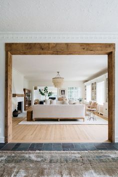 an image of a living room with wood floors and white couches in the middle