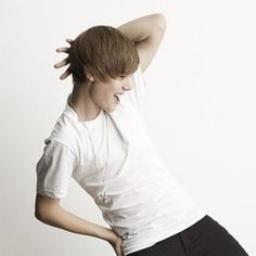 a woman in black shorts and a white t - shirt with her hands behind her head