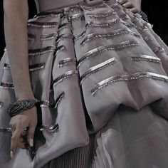 a woman's hand is on the skirt of a dress that has silver stripes