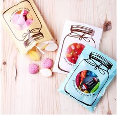 two bags of candy sitting on top of a wooden table next to some candies