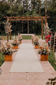 an outdoor ceremony setup with flowers and greenery