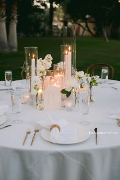 the table is set with candles, plates and napkins for an elegant wedding reception