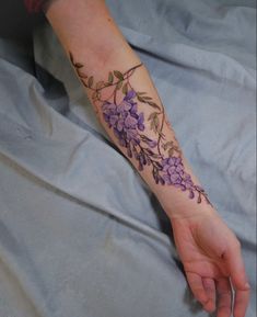 a woman's arm with purple flowers on it