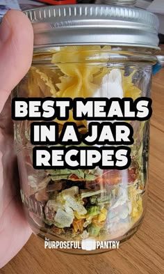 a person holding up a jar full of food with the words best meals in a jar recipes