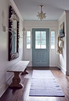 a hallway with a blue door and wooden bench