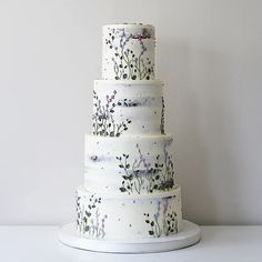 a three tiered cake with flowers painted on it