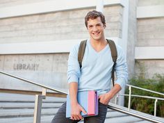 a young man is sitting on the steps with his backpack and books in his hand