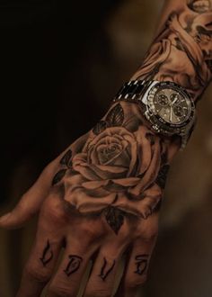 a person's hand with tattoos on it and a rose tattooed on the wrist