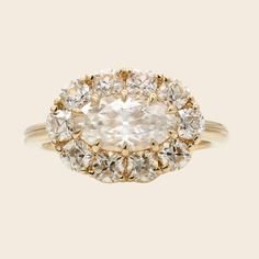 an oval shaped diamond ring with two rows of diamonds around the band, set in yellow gold