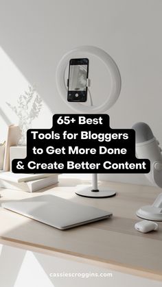 a desk with a laptop, mouse and cell phone on it that says 65 best tools for bloggers to get more done