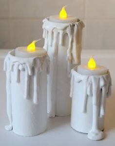 three white candles sitting next to each other