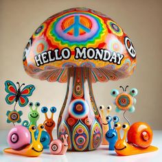 a group of colorful snails sitting on top of a mushroom shaped object with the word hello monday written on it