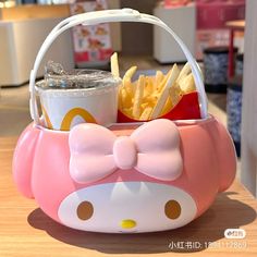 a hello kitty basket with french fries and ketchup in it on a table