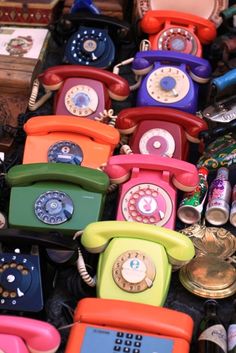 many different colored telephones are stacked on top of each other