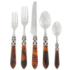 five pieces of silver and tortoise shell utensils with matching flatware