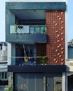 an apartment building with two balconies and plants growing on the top floor balcony