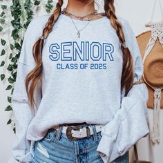 a woman with long hair wearing a sweatshirt that says senior class of 205 on it