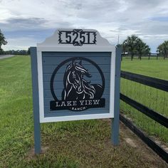 the sign for lake view ranch is in front of a fence and grassy field with trees