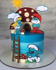 there is a cake that looks like the smurfs are on top of it