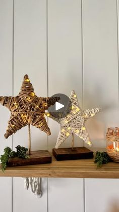 two wooden stars are sitting on a shelf with some candles and other decorations around them