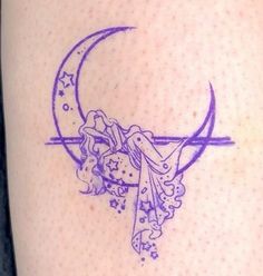 a woman's thigh with a tattoo design on the side of her leg that has a crescent moon and stars around it