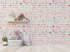 a teddy bear sitting in a basket next to a wall with polka dots on it