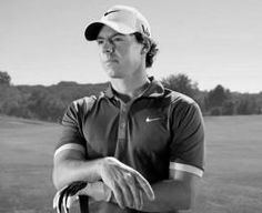 a man standing on top of a lush green field holding a golf racquet