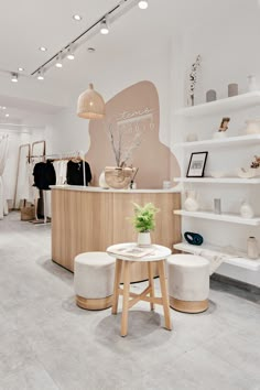 the interior of a clothing store with shelves and stools