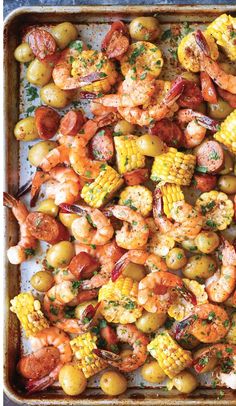 shrimp, corn and potatoes on a baking sheet