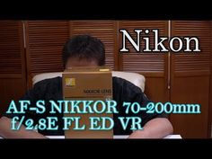 a man sitting in front of a box with the words nikon on it and an image