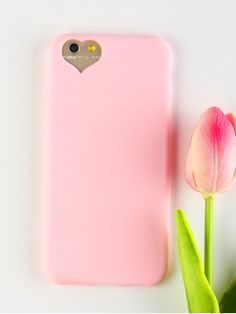 a pink phone case sitting next to a flower