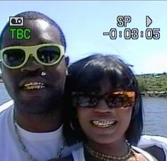 a man and woman with sunglasses on posing for a photo in front of the water