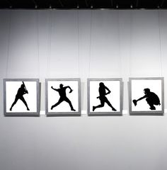 four silhouettes of baseball players hanging on the wall in front of a white background