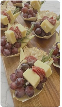 grapes, cheese and crackers are arranged on small plates