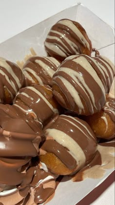 chocolate covered donuts in a box on a table