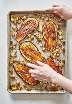 a person reaching for some food on a pan