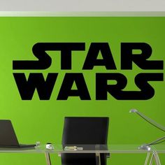 the star wars logo is shown on a wall above a glass table with two laptops