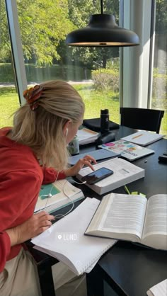 a woman sitting at a table with an open book