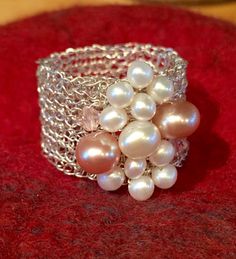 a close up of a bracelet with pearls on it