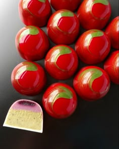 a pile of red apples sitting on top of a table next to a piece of paper