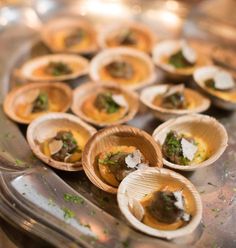 there are many small bowls with food in them on the tray, ready to be eaten