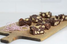 several pieces of chocolate on a wooden cutting board with a string tied to the side