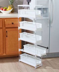 a kitchen with a white refrigerator and shelves filled with fruit on the counter next to it