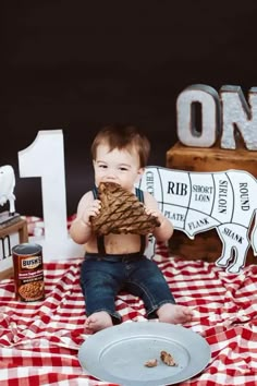 a baby sitting on top of a red and white checkered table cloth eating food