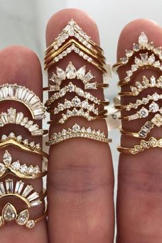 there are many different types of rings on this hand, all in gold and diamonds