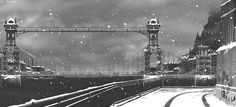 a black and white photo of a snowy night with the brooklyn bridge in the background