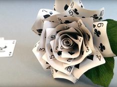 a rose made out of playing cards sitting on top of a table