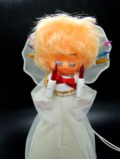 an orange doll wearing a white dress and veil