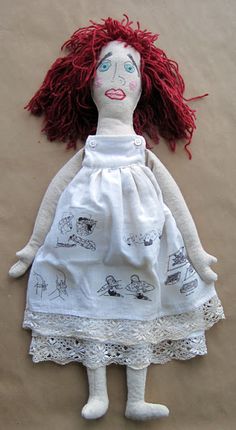 a doll with red hair wearing a white dress