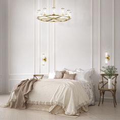 a bedroom with white walls and gold chandelier